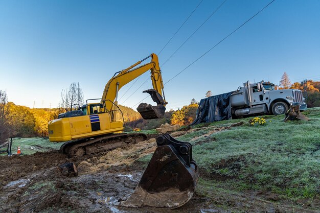 La pelle sur chenilles jaune charge le sol sur un gros camion