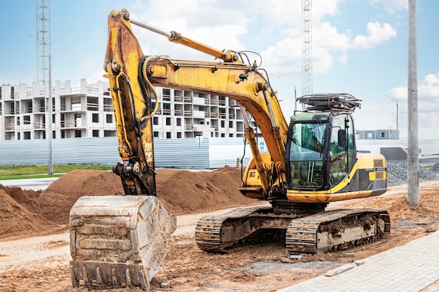 Pelle sur chenilles lourde avec un grand seau sur fond de ciel coucher de soleil. Matériel de construction lourd pour les travaux de terrassement. Amélioration du territoire.