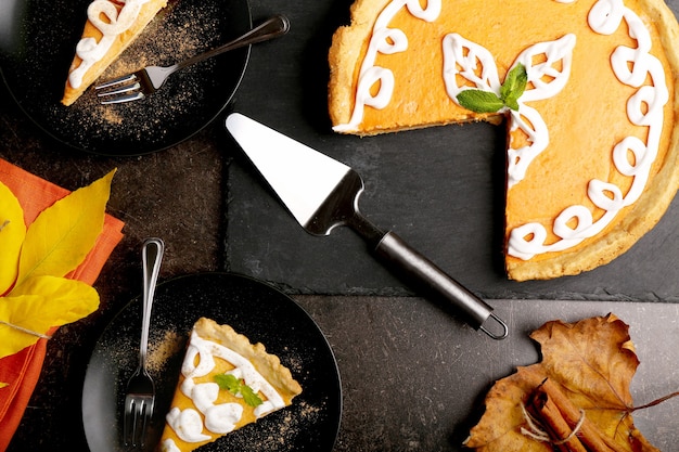 Pelle et délicieux gâteau à la citrouille avec décoration crème sur plaque d'ardoise