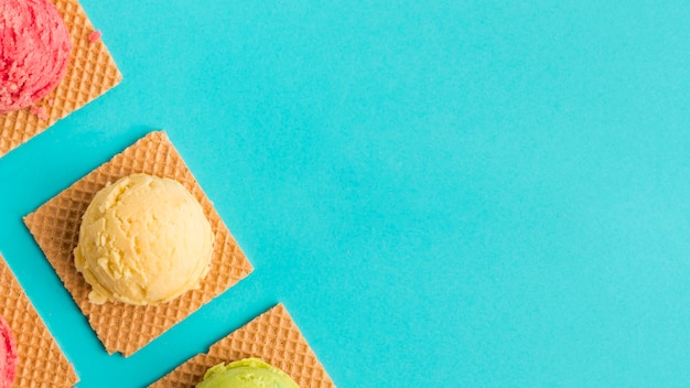 Photo pelle à glace congelée sur des gaufres sur une surface turquoise