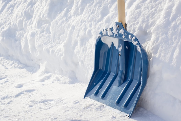 Pelle à neige avec manche en bois après avoir nettoyé le trottoir dans la rue