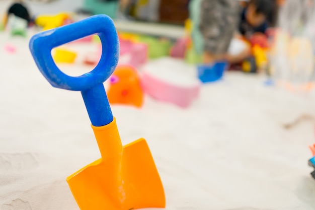 Pelle en plastique coloré pour les enfants dans l&#39;aire de jeu de bac à sable.