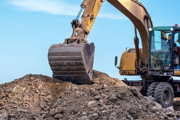 La pelle sur pneus effectue des travaux de construction de routes en gros plan