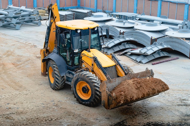 Une pelle polyvalente avec un godet avant transporte le sol sur le chantier de construction Vue d'en haut Machines de construction pour les travaux de terrassement