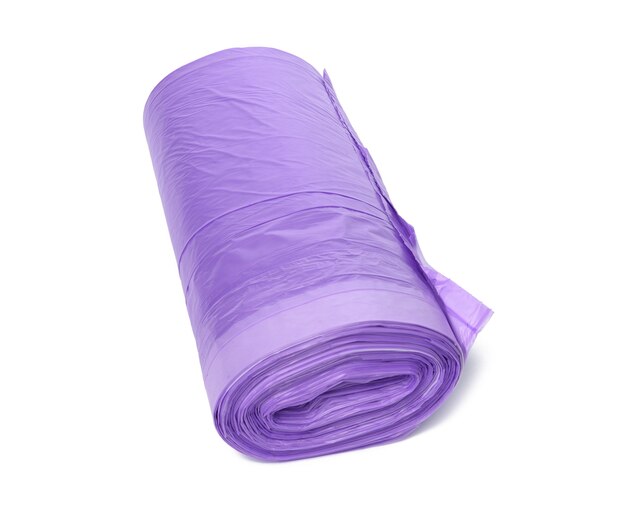 Pelote de sacs poubelle en plastique violet avec des cordes isolé sur fond blanc