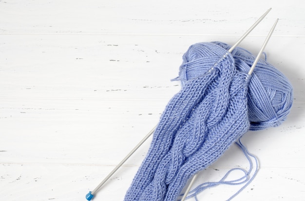 Pelotes de laine bleue et aiguilles à tricoter. Le concept de la couture féminine