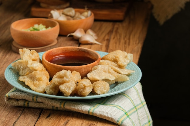 Pempek servi sur une table en bois rustique. Le pempek est un plat traditionnel indonésien. à base de poisson et de tapioca servi avec une riche sauce aigre douce et spéciale ou une sauce au vinaigre appelée cuka