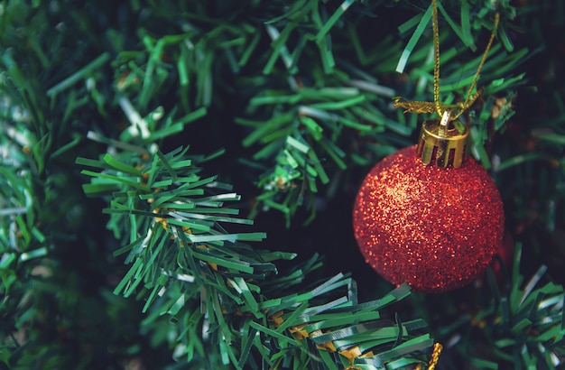 Pendaison de boules rouges sur des branches de pin, guirlande et ornements de Noël