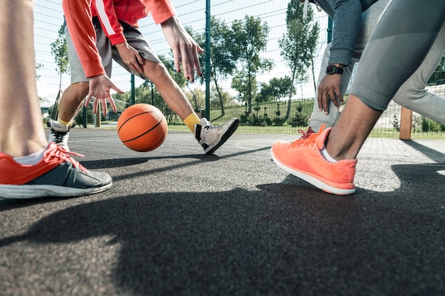 Pendant la partie. Gros plan d'un ballon de basket-ball transmis à différents joueurs pendant le jeu