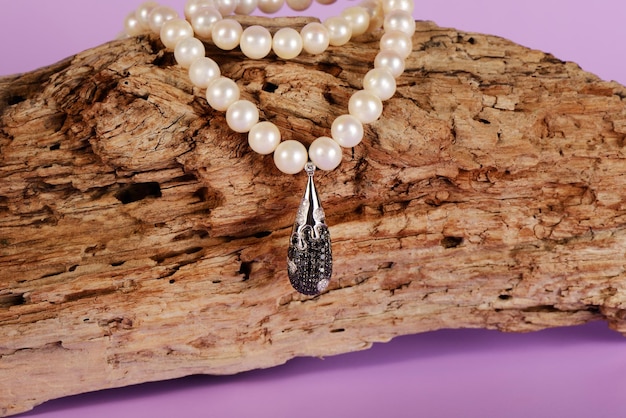 Pendentif en platine pour femme avec un collier de diamants noirs et blancs sur un collier de perles précieuses