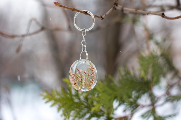 Un pendentif en verre avec des fleurs de bruyère magiques gelées à l'intérieur du Talisman de guérison magique