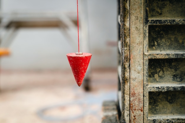 Pendule avec prune pour trouver la ligne verticale