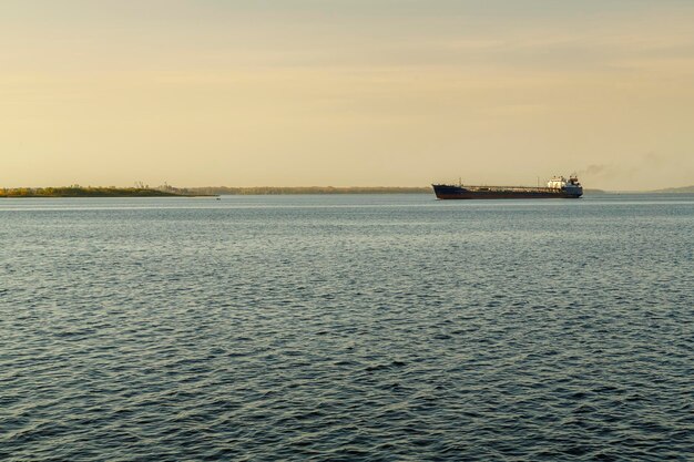 Une péniche au loin sur l'eau d'une grande rivière navigable. photo horizontale