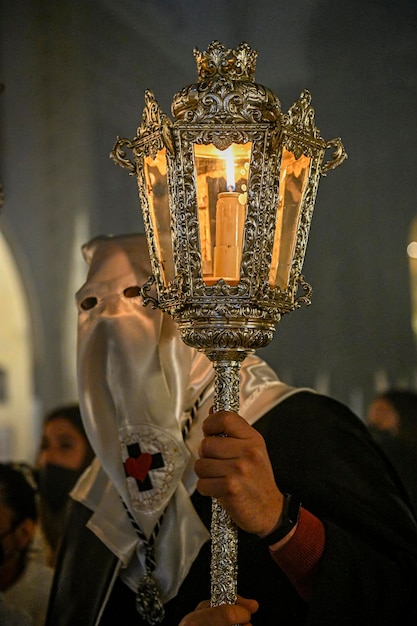 Pénitent avec un chandelier dans une procession en semaine sainte