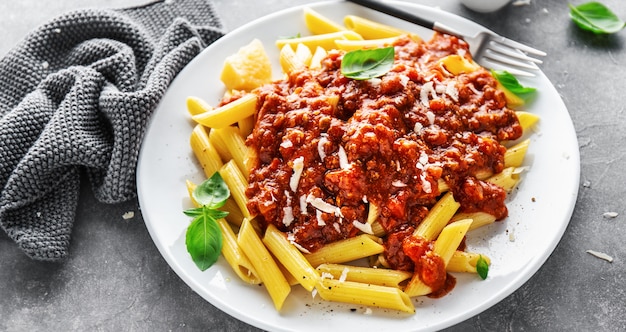 Penne bolognaise servie sur assiette