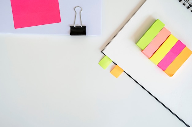 Pense-bête et cahier sur fond blanc.