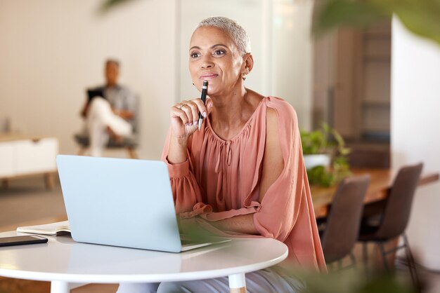 Pensée de bureau et femme mûre avec une idée pour une entreprise de démarrage créative ou une planification d'horaire dans un ordinateur portable au bureau Concepteur de travailleur indépendant ou stylo à la main travaillant sur des idées dans un bureau moderne