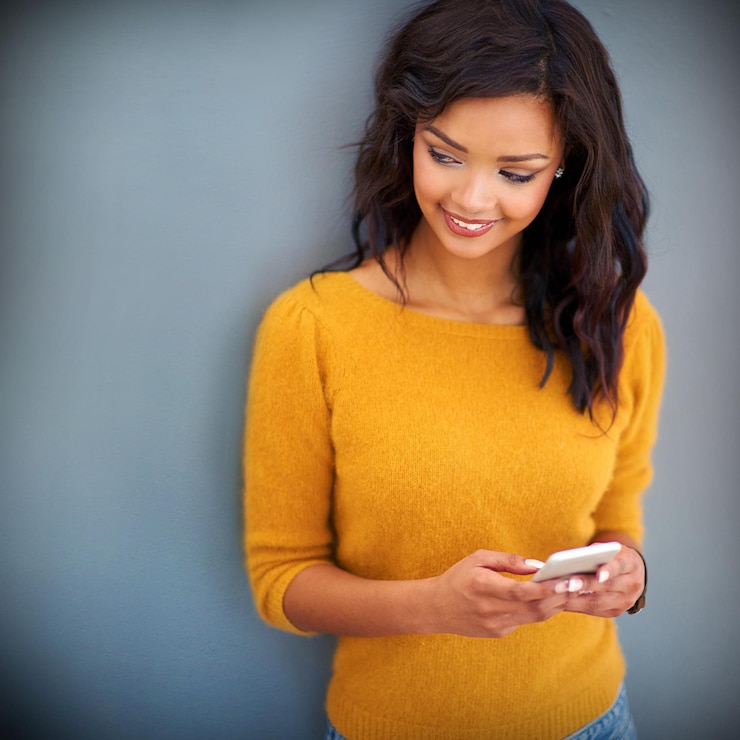 Photo pensée heureuse et femme avec smartphone en studio pour les médias sociaux poste en ligne et notification téléphone personne féminine et sourire avec la technologie pour le chat de message texte ou le contact sur fond gris