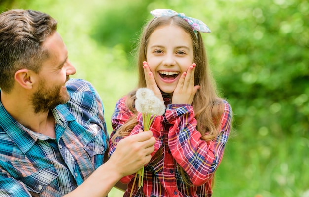 Penser l'écologie. petite fille et papa homme heureux. Jour de la Terre. pays du village de printemps. ferme familiale d'été. écologie. Bonne journée en famille. fille et père aiment la fleur de pissenlit.