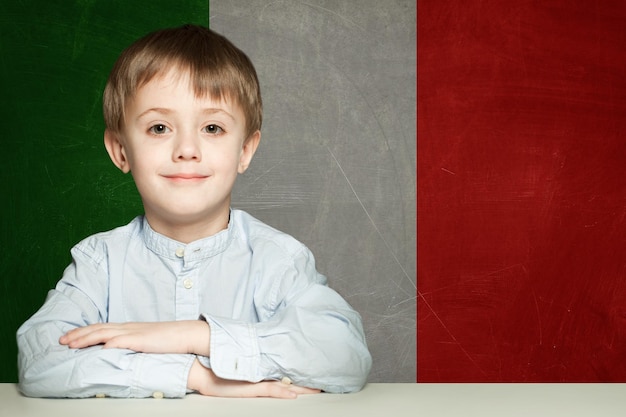 Penser enfant garçon étudiant contre le fond du drapeau Italie Il