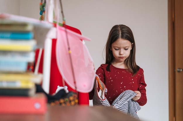 Penser Entre Petite Fille Aux Longs Cheveux Noirs En Robe Rouge Parmi Ses Belles Robes En Armoire Dans La Chambre Des Enfants à La Maison