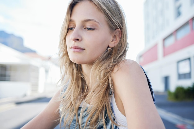 Penser fille dans la rue dans la ville expression triste sur son visage Jeune étudiant assis sur la route dans une ville urbaine avec des pensées conscientes dépression et santé mentale Femme seule tristesse et stress