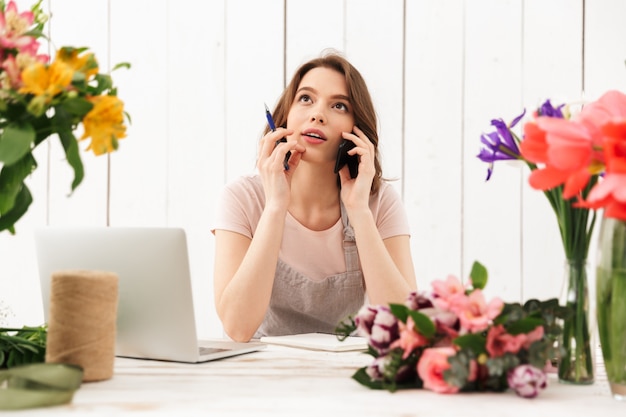 Penser la fleuriste dame sur les fleurs en atelier