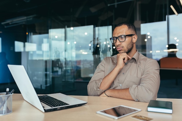 Penser homme d'affaires hindou dans des verres programmeur développeur travaillant à l'intérieur du bureau de moderne