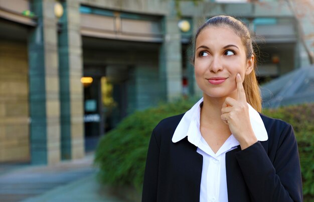 Penser la jeune femme d'affaires a eu une idée et à la recherche de l'espace de copie latérale à l'extérieur.