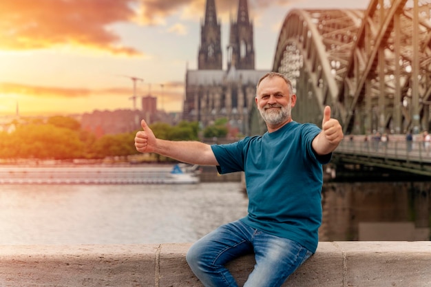 Pensionné voyageant à travers l'Europe en train un homme barbu assis sur le quai du Rhin