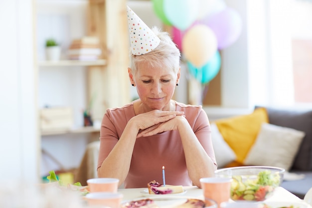 Pensive femme âgée fête son anniversaire seul