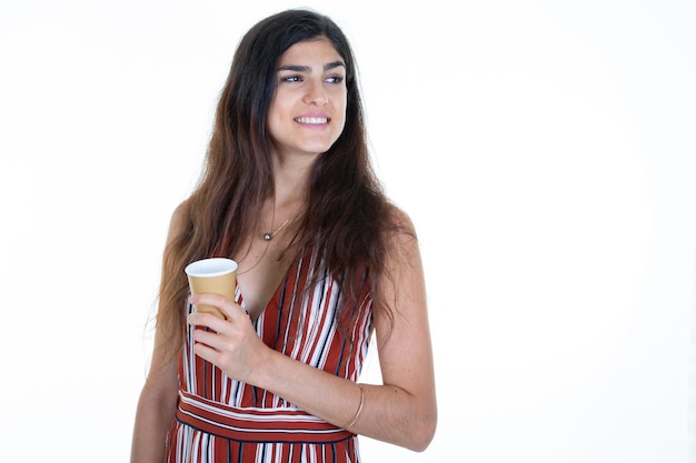 pensive jolie femme rêveuse tient une tasse de café en carton dans les mains