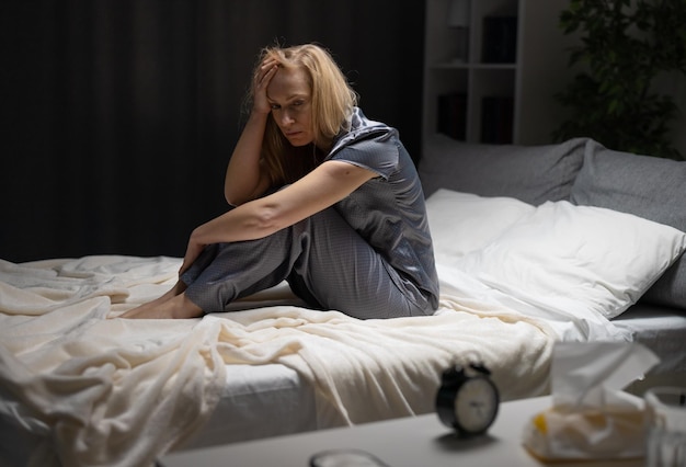 Pensive mature woman holding hands on