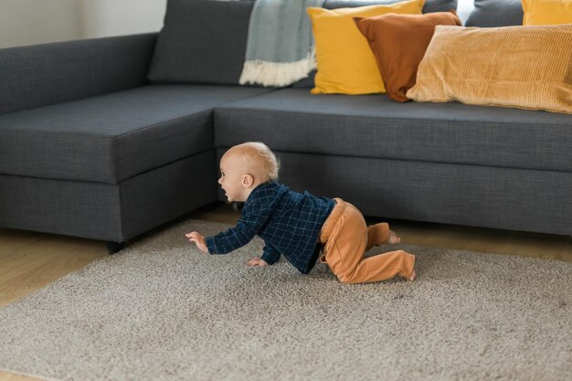 Pépinière bébé garçon rampant sur le sol à l'intérieur à la maison copiez l'espace et l'espace vide pour le texte La curiosité du bébé et les stades de développement de l'enfant