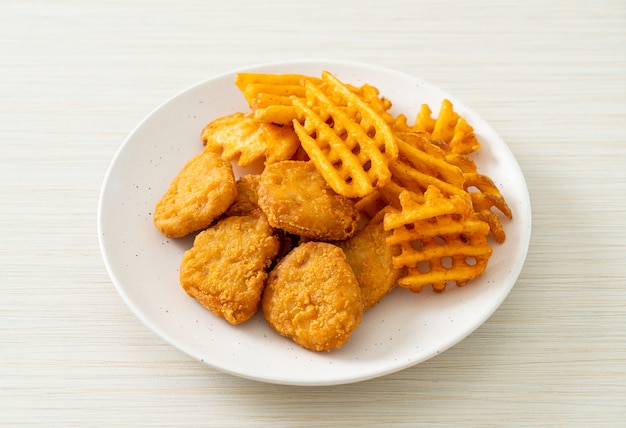 pépites de poulet frit avec pommes de terre frites sur plaque