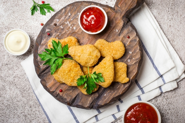 Pépites de poulet frites croustillantes avec des sauces populaires en gros plan