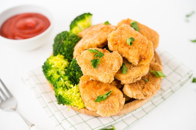 Pépites de poulet maison avec des légumes sur une assiette