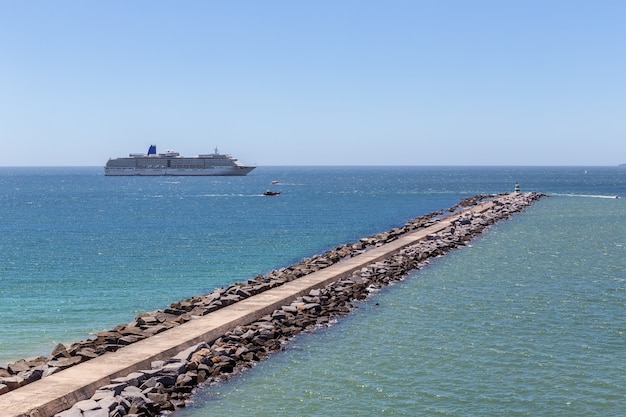 Percer le brise-lames en face du bateau de croisière à Portimao.