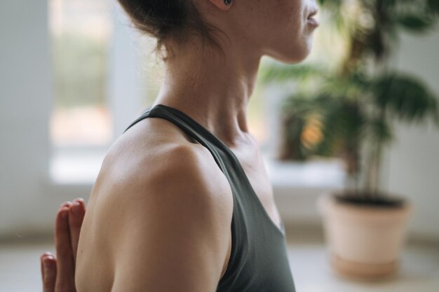 Photo perdre le portrait d'une jeune femme en forme pratiquant le yoga faisant des asanas dans un studio de yoga léger avec une plante verte