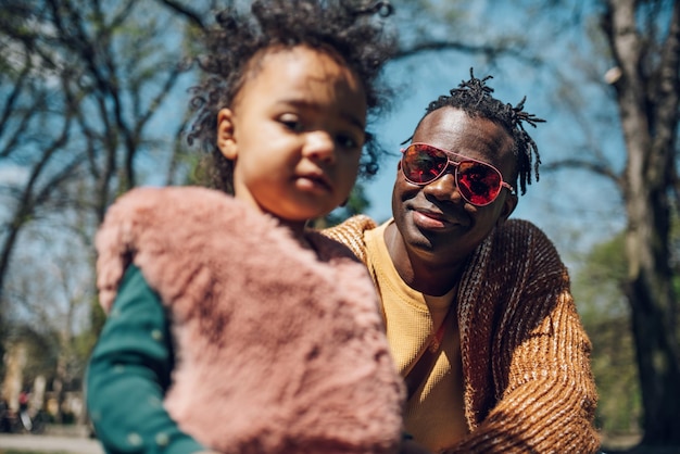 Un père afro-américain passe du temps avec sa fille dans le parc