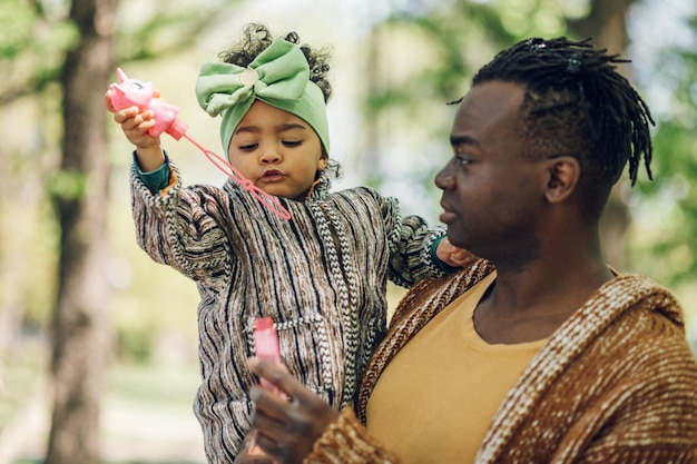 Un père afro-américain passe du temps avec sa fille dans le parc