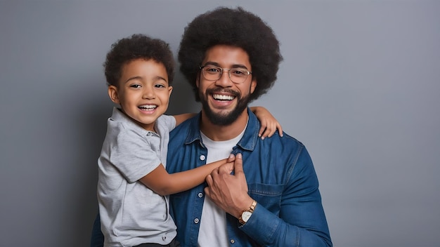 Un père afro et un fils noir sur un fond gris souriants et heureux. Un père afro à la fête des pères.