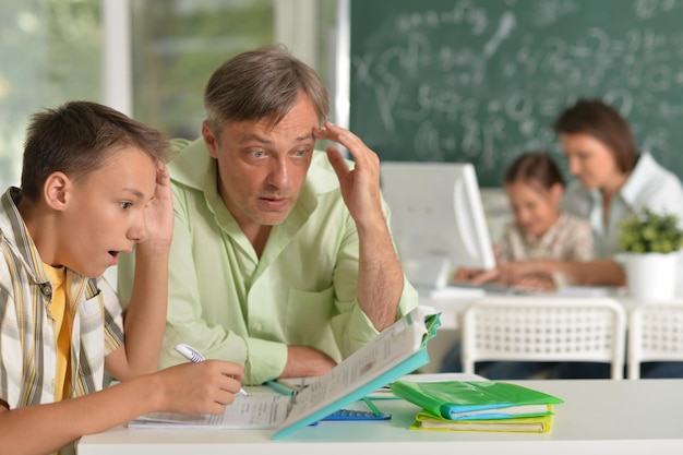 Père aidant son fils à faire ses devoirs en classe