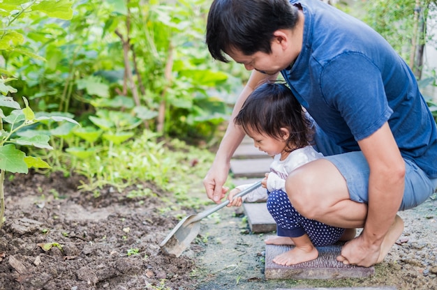 Père asiatique et sa fille dans le petit jardin de légumes à la maison.