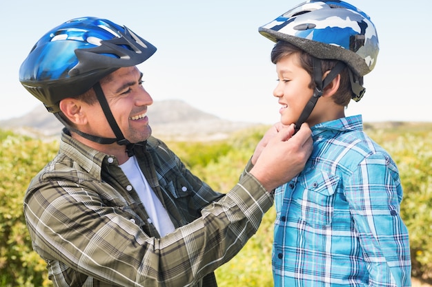 Père attachant son casque de vélo fils