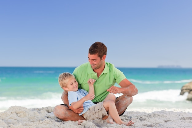 Père attentif avec son fils à la plage