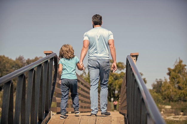 Père célibataire menant un petit enfant à l'extérieur de l'enfance vue arrière