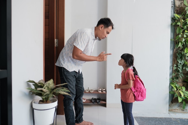 Un père en colère affronte son enfant après l'école. problème des élèves du primaire asiatiques. parent abusif avec sa fille