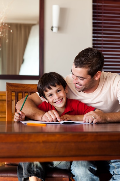 Père concentré aidant son fils à faire ses devoirs