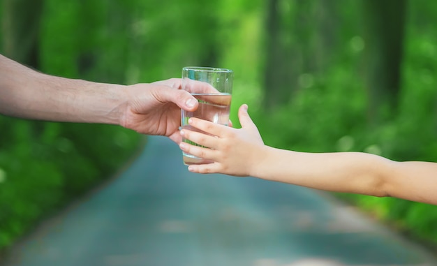 Père donnant à l'enfant un verre d'eau